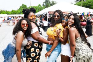 Friends enjoying a sunny day together at an outdoor food festival.