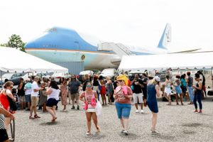 Air Force One aircraft surrounded by crowds of visitors at an outdoor event.