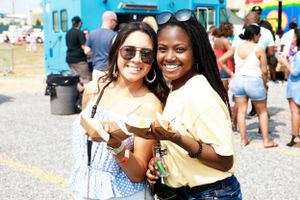 Festival attendees enjoying food and drinks at an outdoor summer event.