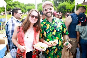 Festival-goers holding food plates at an outdoor summer event.