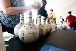Row of decorative white ceramic bottles displayed on a black table.