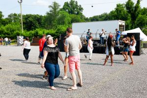 People dancing in front of an outdoor stage with live band performing in background.