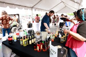 Bar setup at an outdoor event with various bottles and mixers on display.