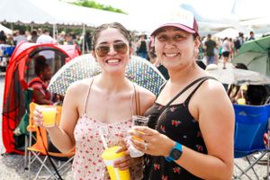 Festival attendees enjoy refreshing drinks on a sunny day at an outdoor event.