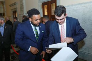 Senator Nick Charles review documents in a hallway of a government building.