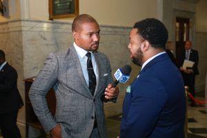 News Anchor Darren Haynes and Senator Nick Charles Interview being conducted in marble hallway of government building.