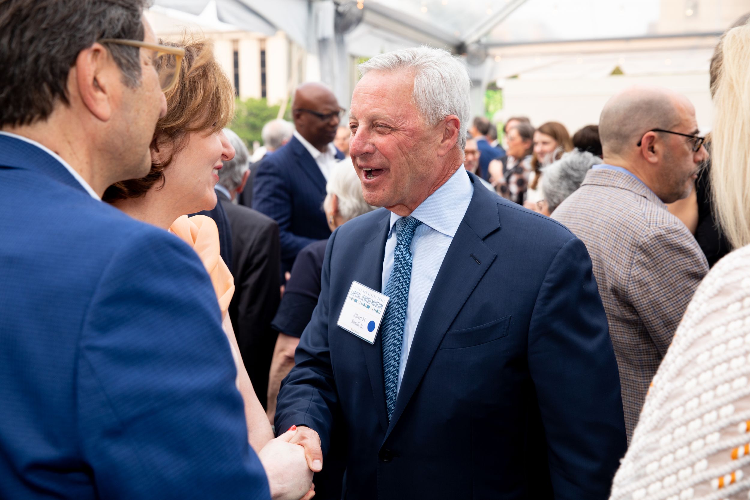 Attendees engage in animated conversation at a formal networking event.