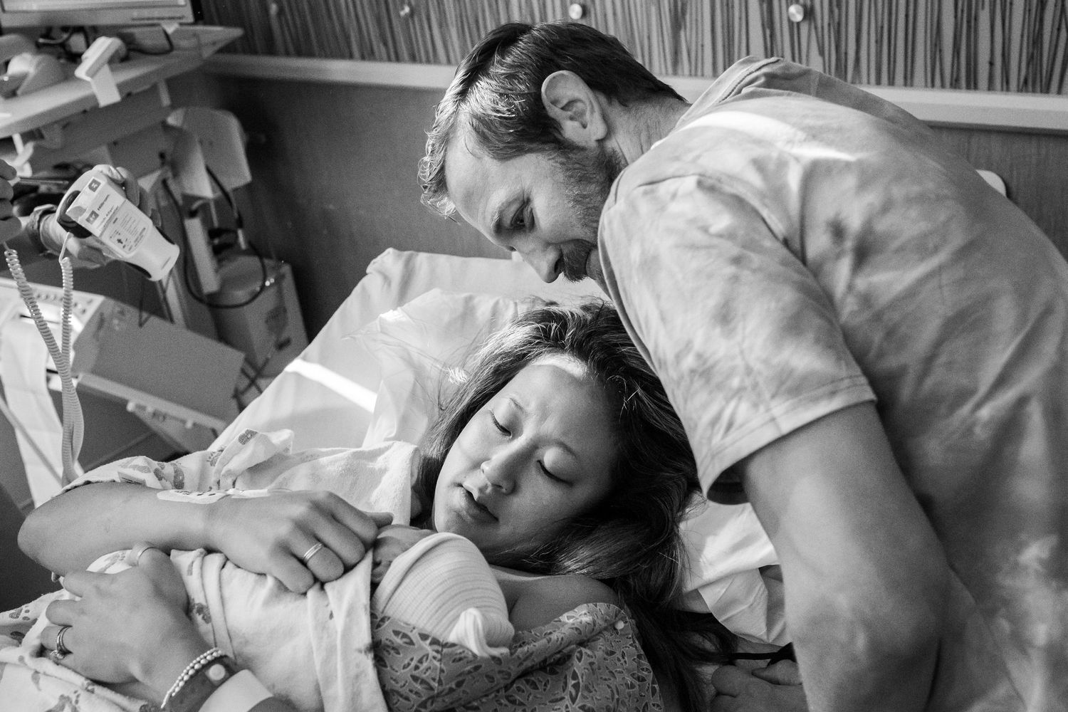 Parents looking at all the features of their brand new baby moments after his birth in San Diego