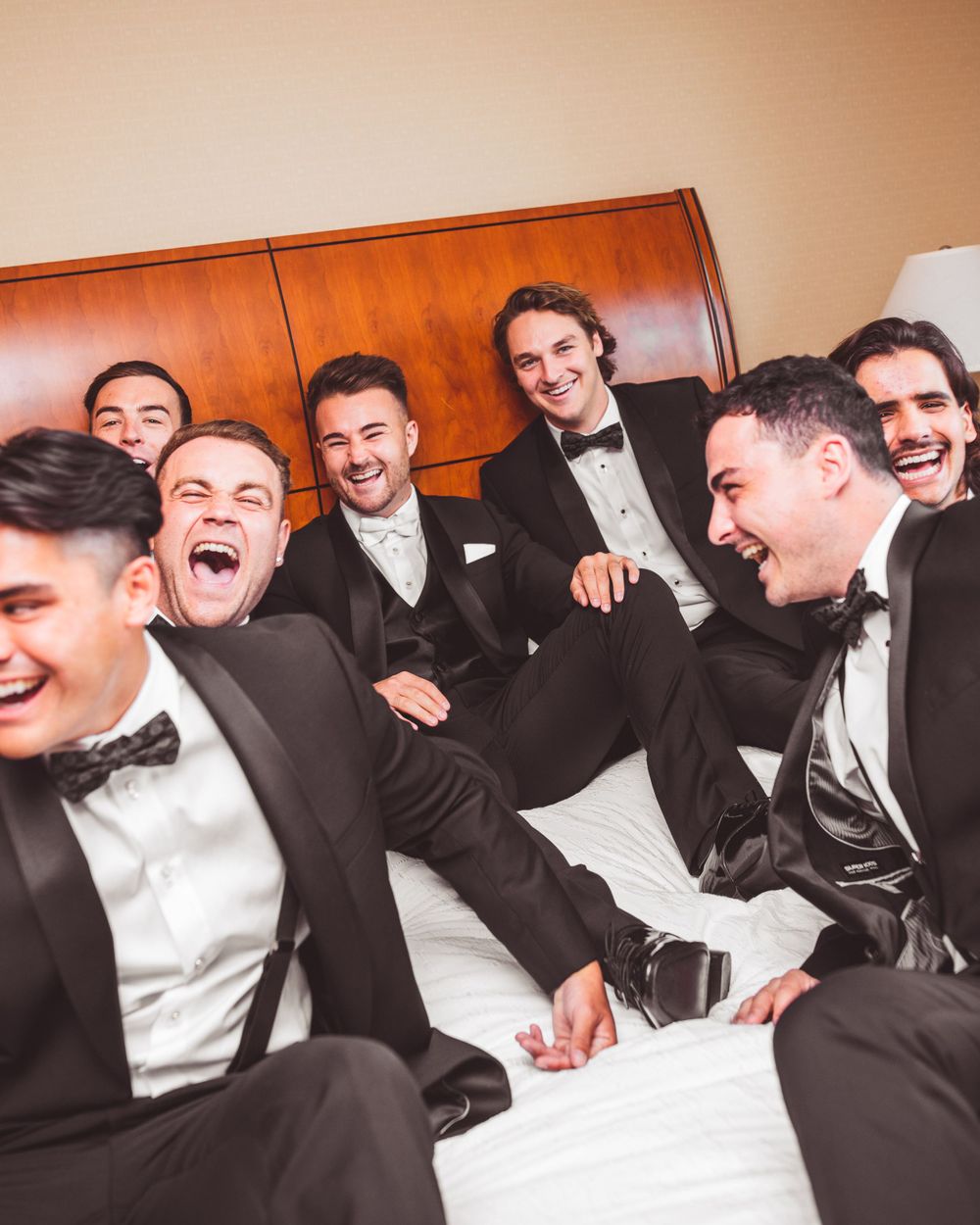 Groomsmen sharing laughs while relaxing before the wedding ceremony.
