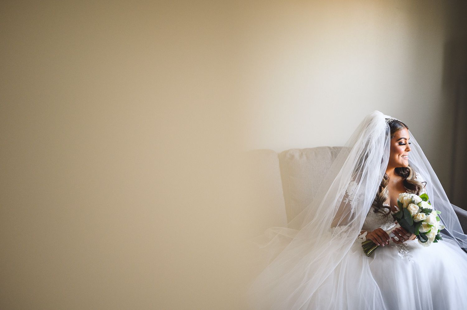 bridal portrait smiling with her flowers during bride prep