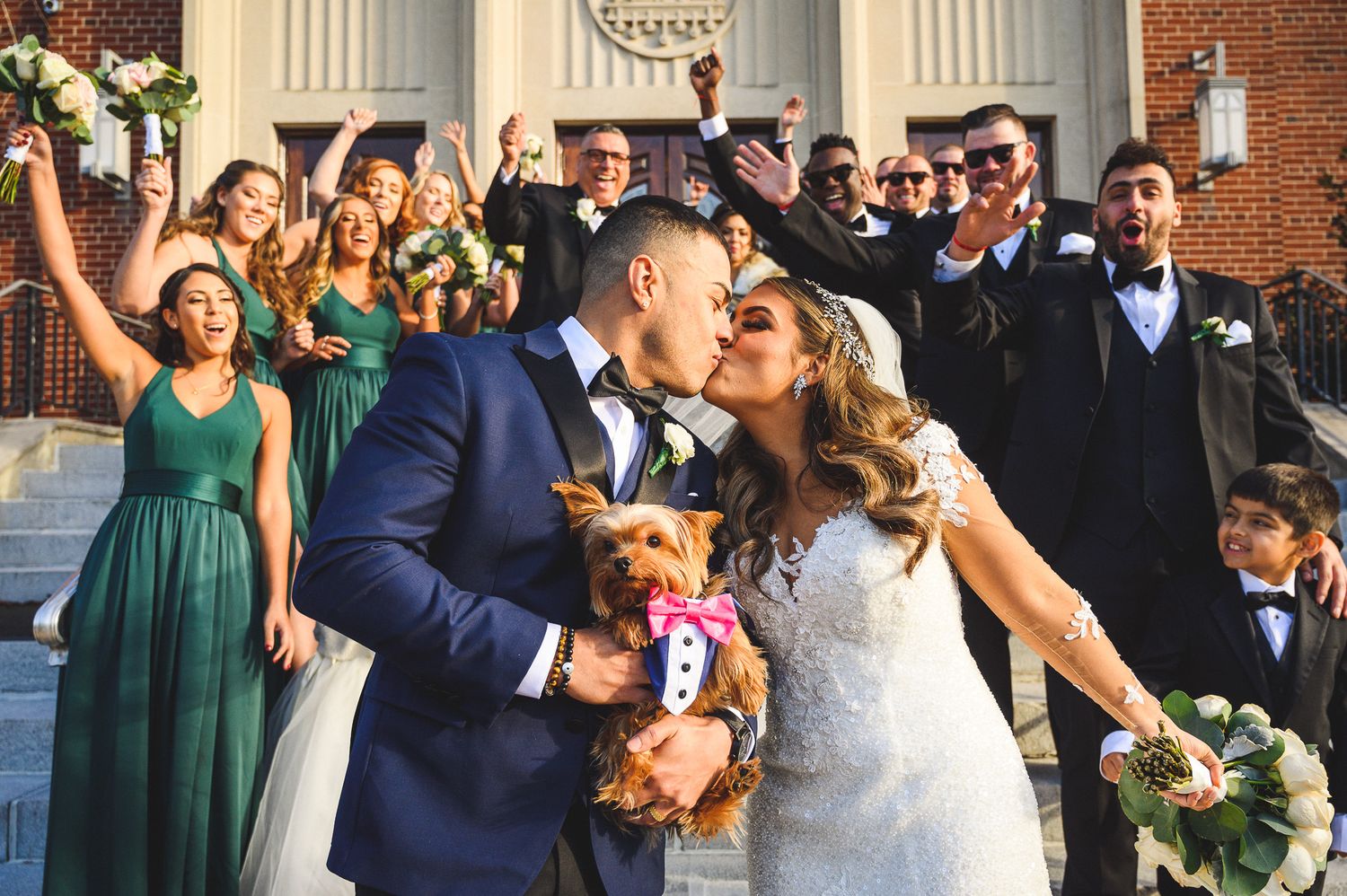 bride and groom kiss outside church with their dog