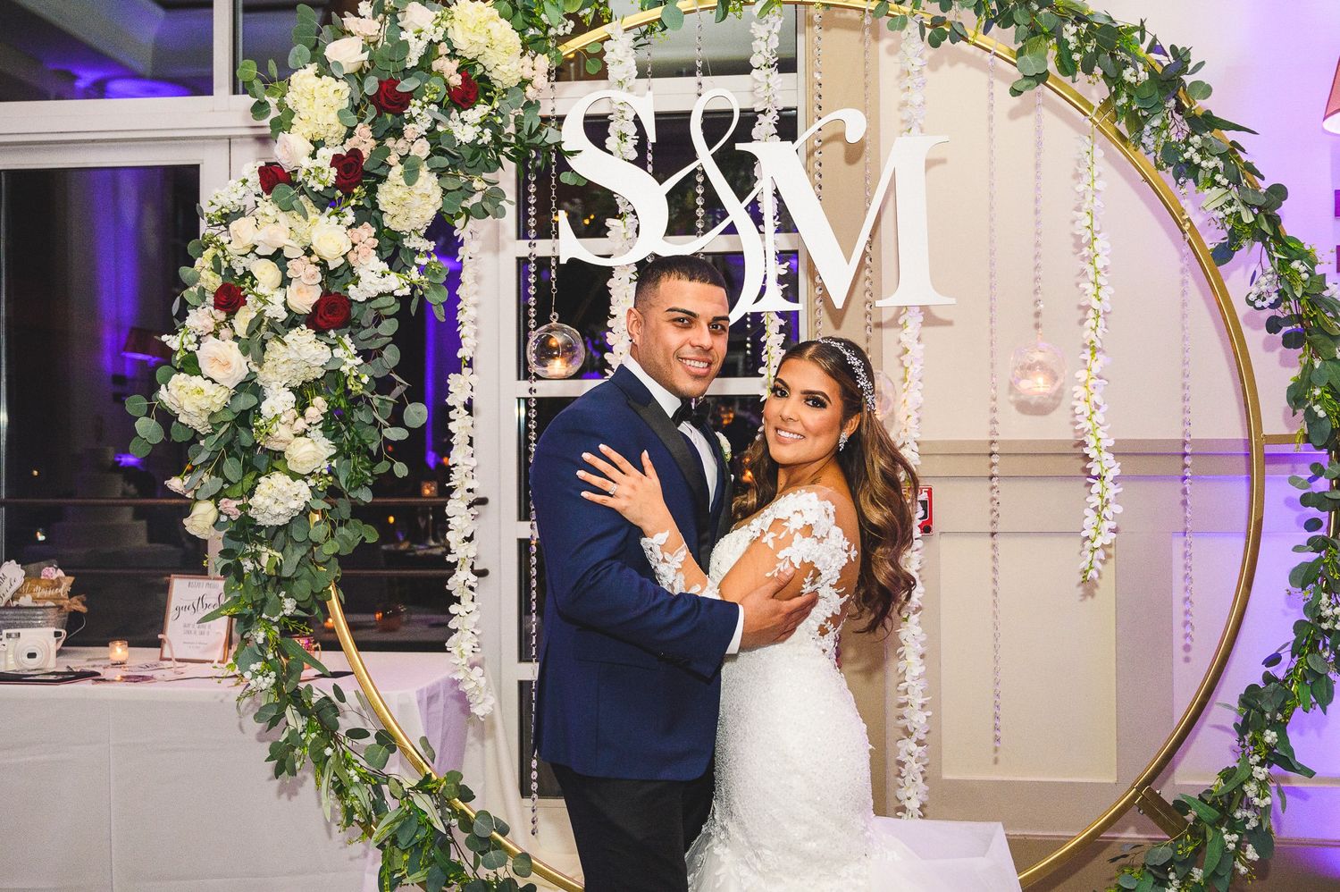 Bride and groom portrait in front flower arbor in reception