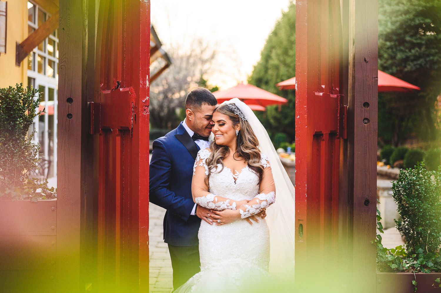 bride and groom portrait in between red doors at stone house