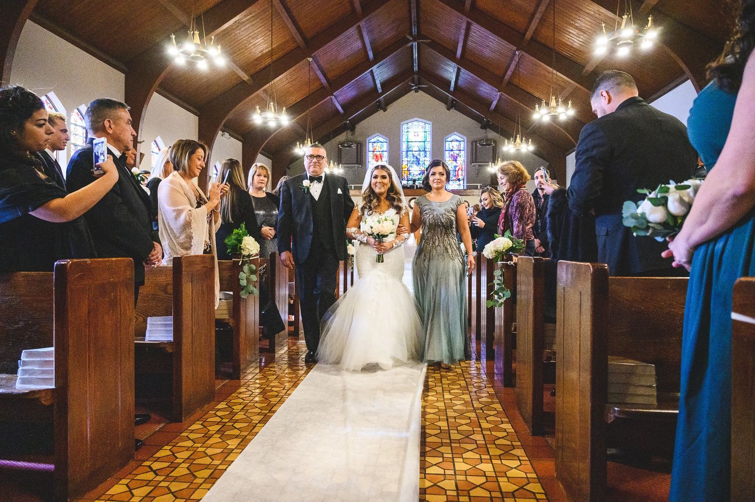 bride coming down isle with mom and dad