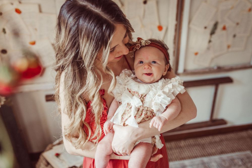 Sweet lifestyle portrait with baby in delicate white lace outfit.