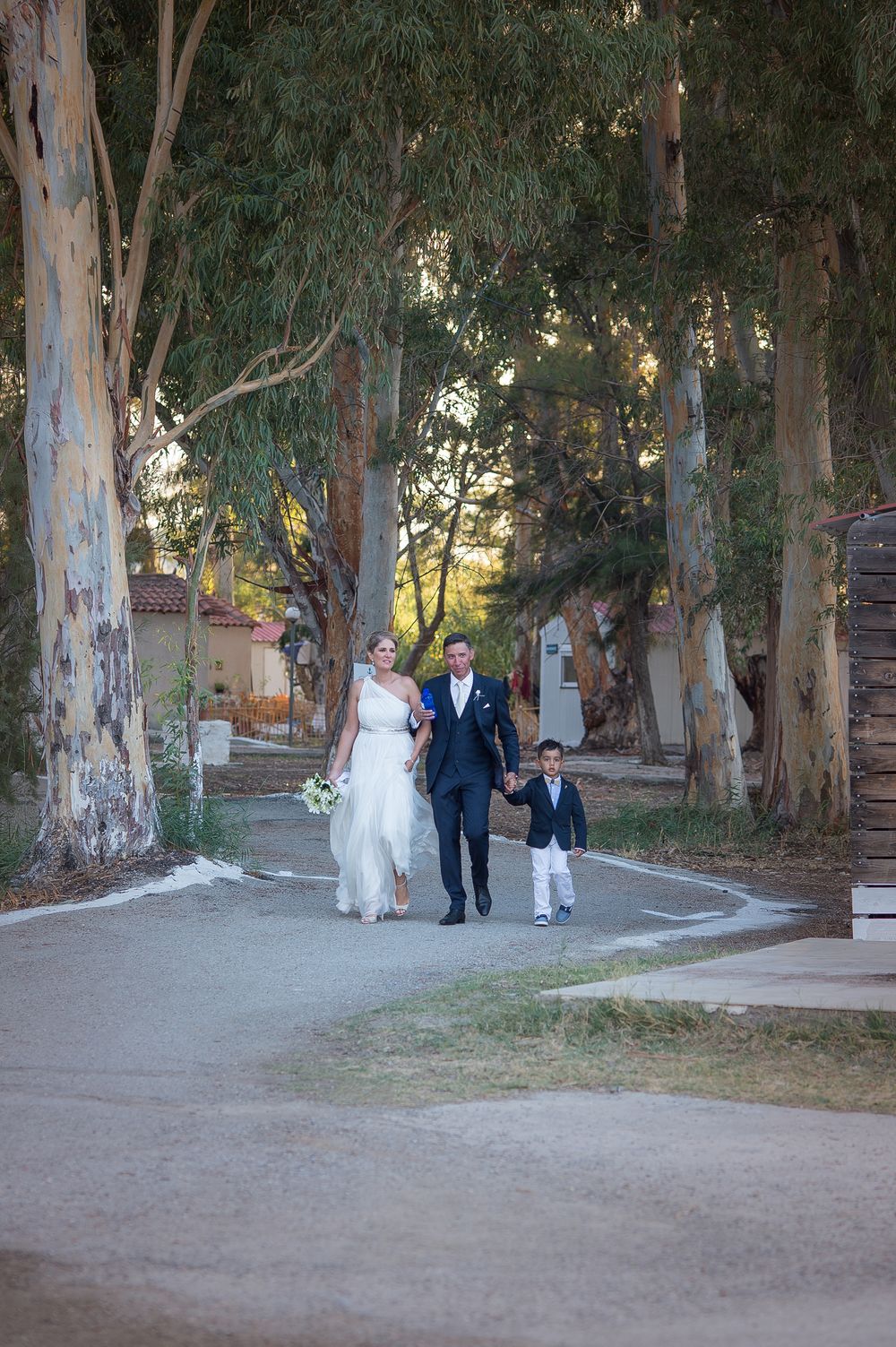 couple with their nephew walking towards the boat which will transfer them to the reception