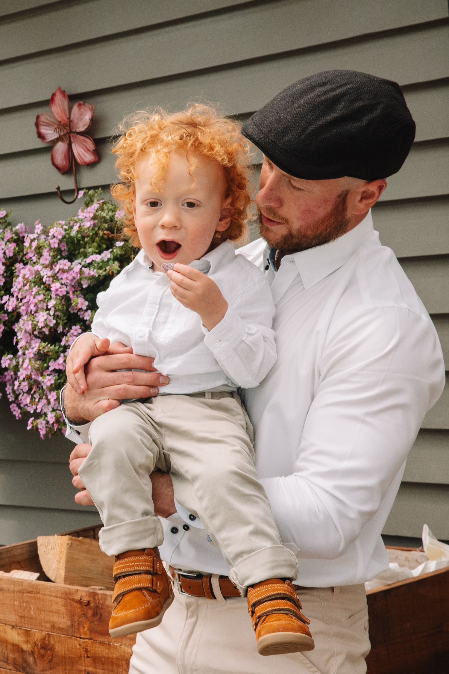 Sweet candid moment with small child in white and khaki outfit outdoors.