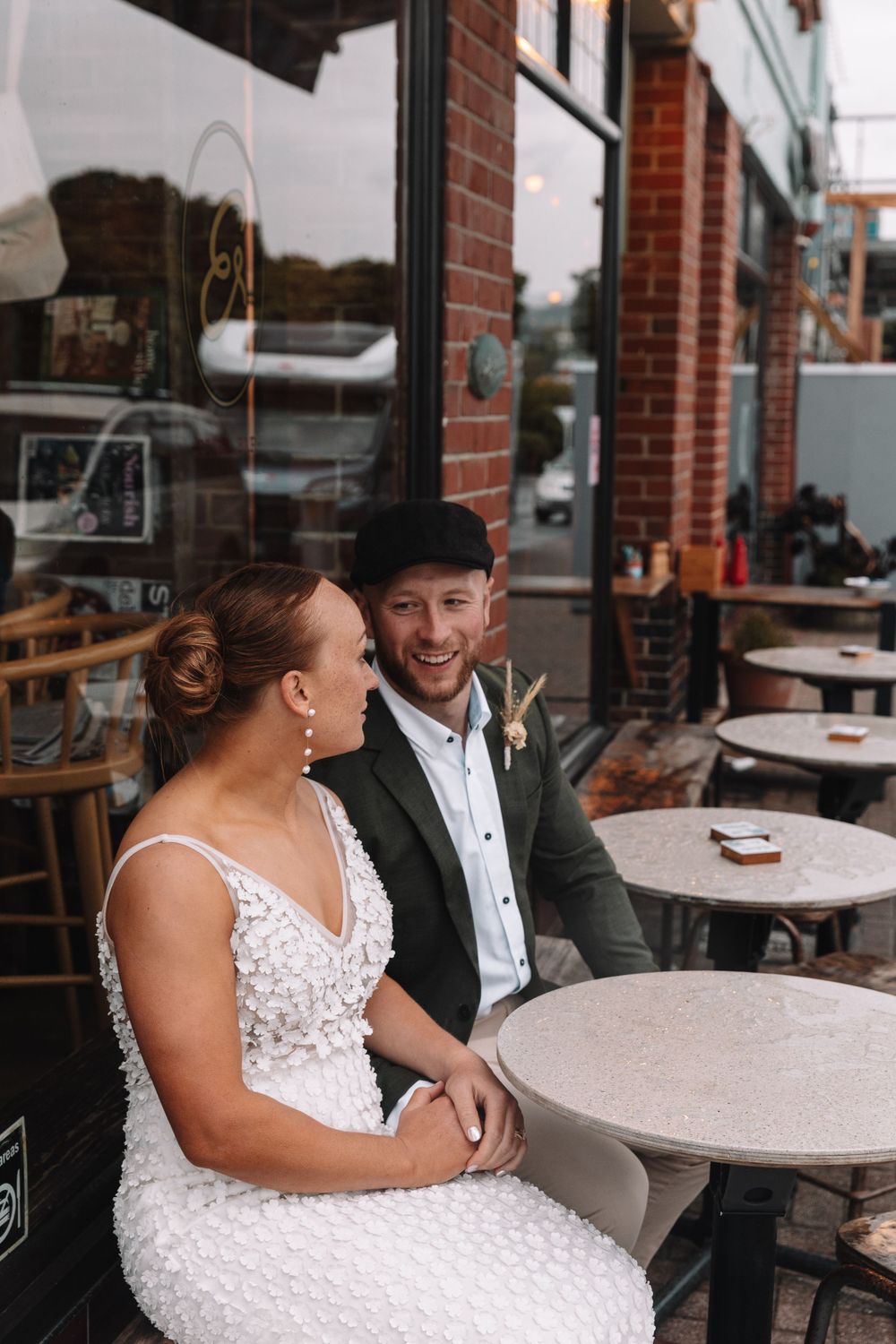 A couple enjoys a candid moment together at an outdoor cafe setting.