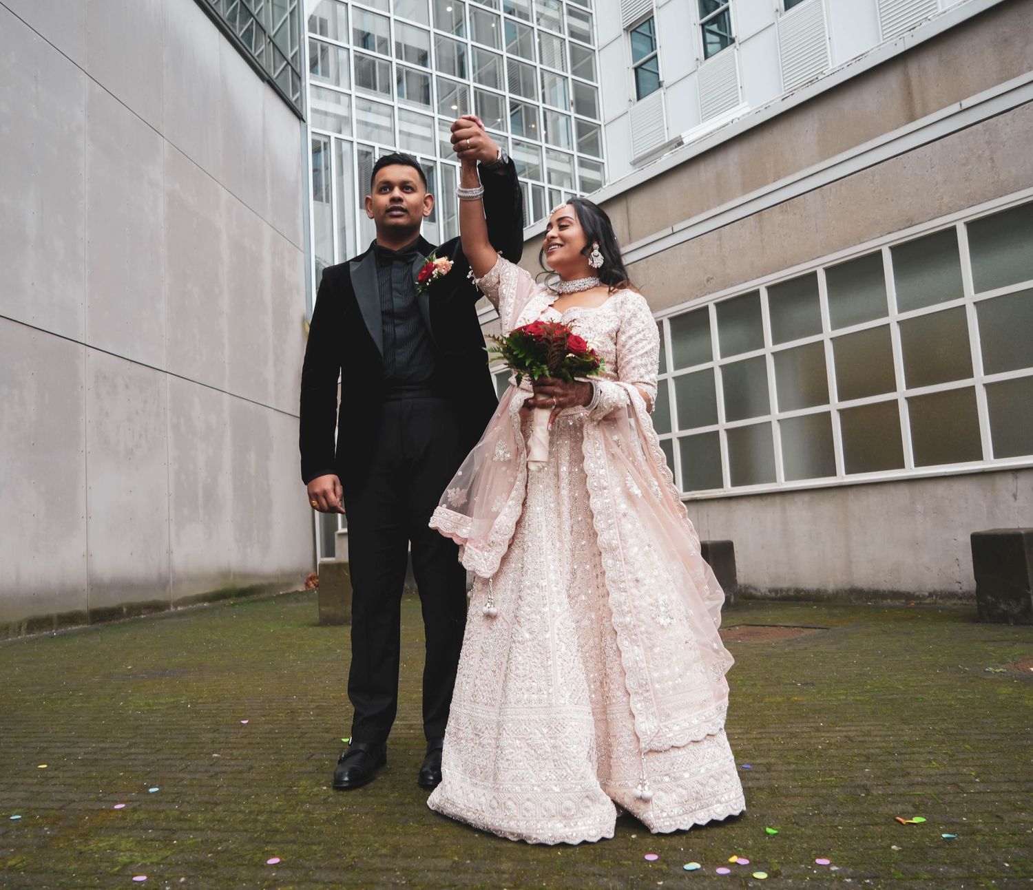 Newlyweds share a joyful moment together on their wedding day in an urban setting.