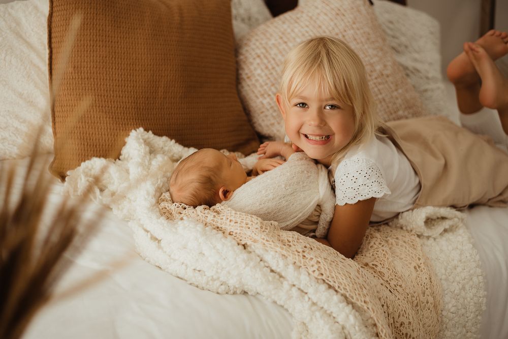 Schwester kuschelt mit ihrem Bruder beim Fotoshooting