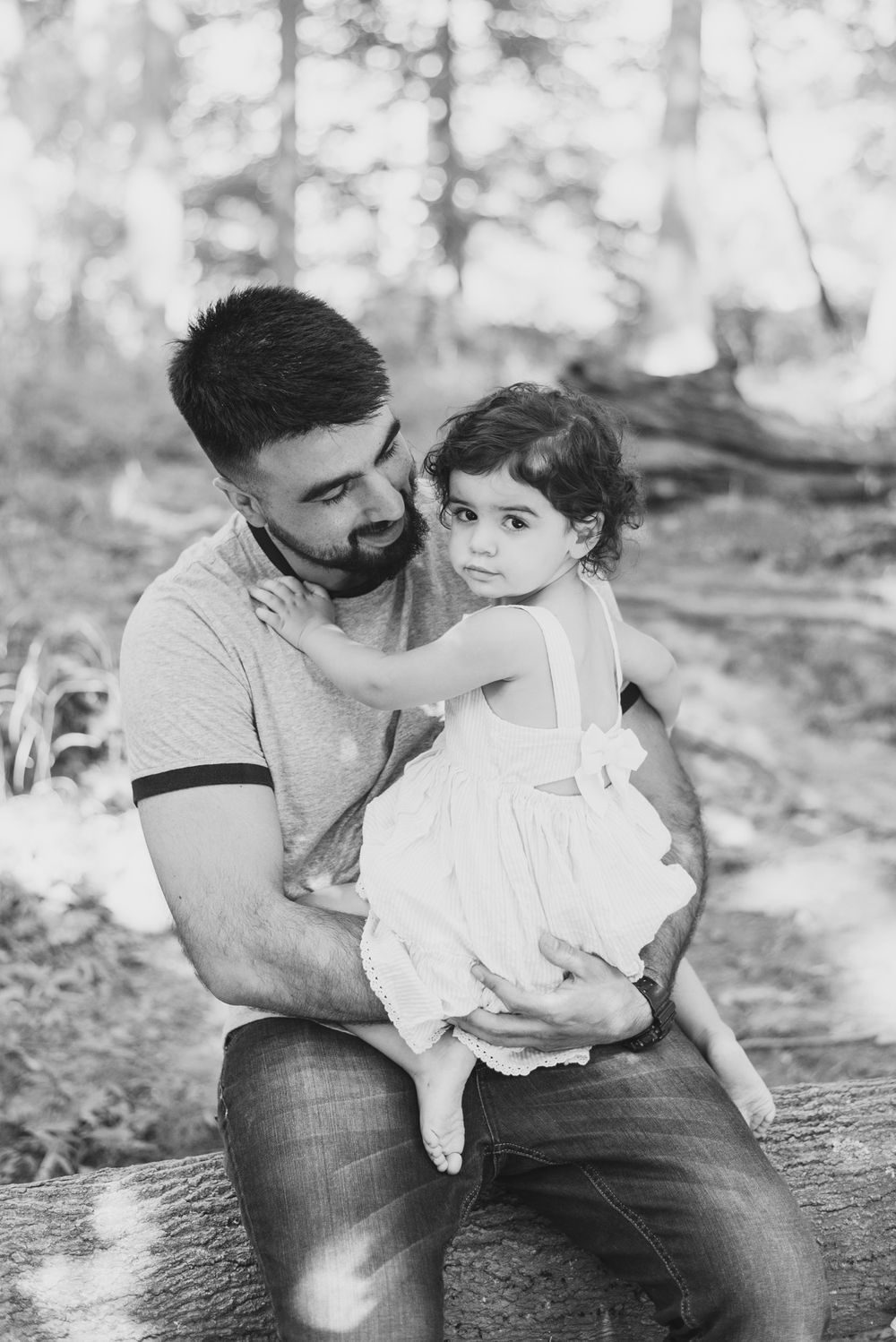 Dad holding toddler on tree branch in black and white in Pittsburgh, Pennsylvania