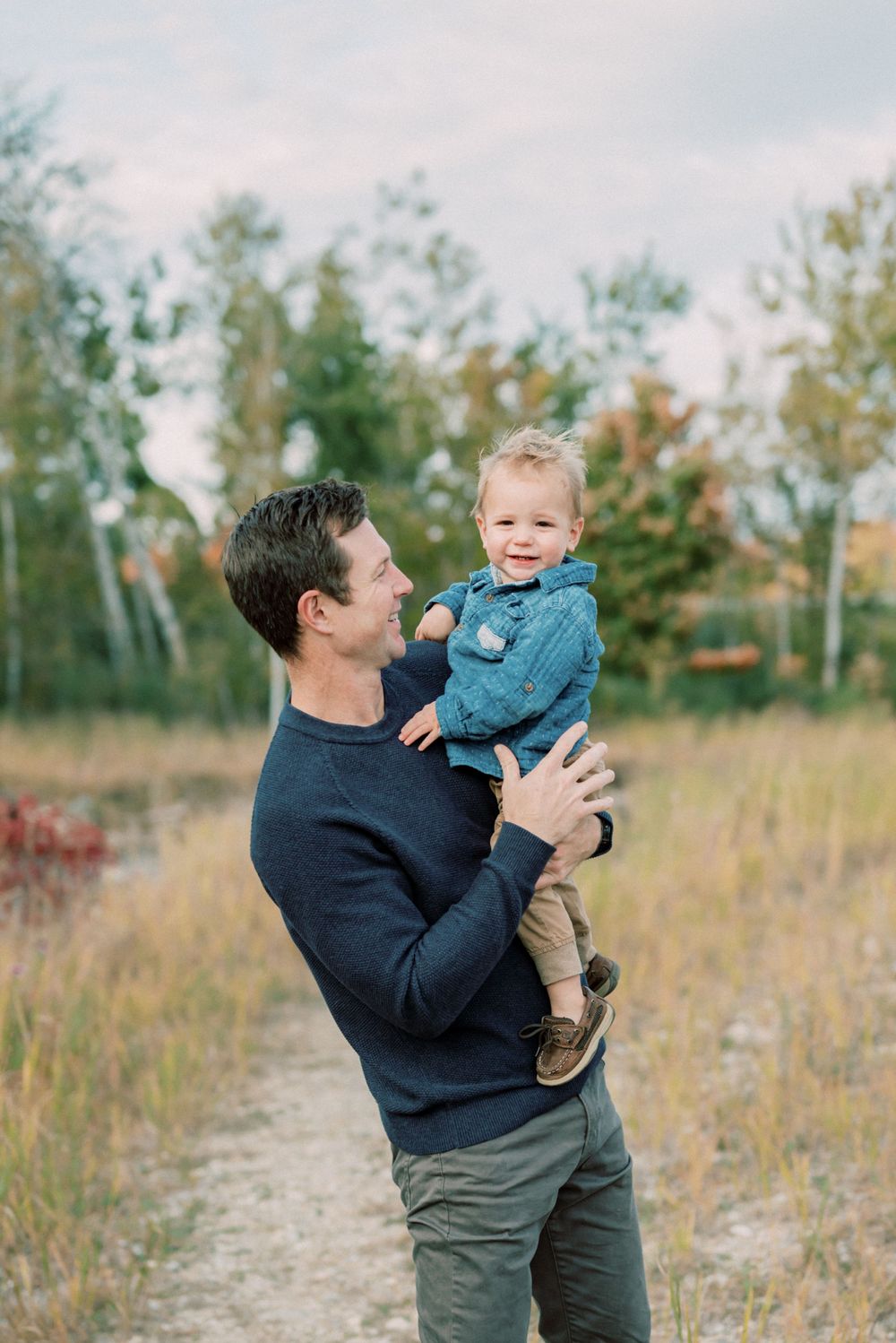 A heartwarming moment captured on a trail with autumn foliage in the background.