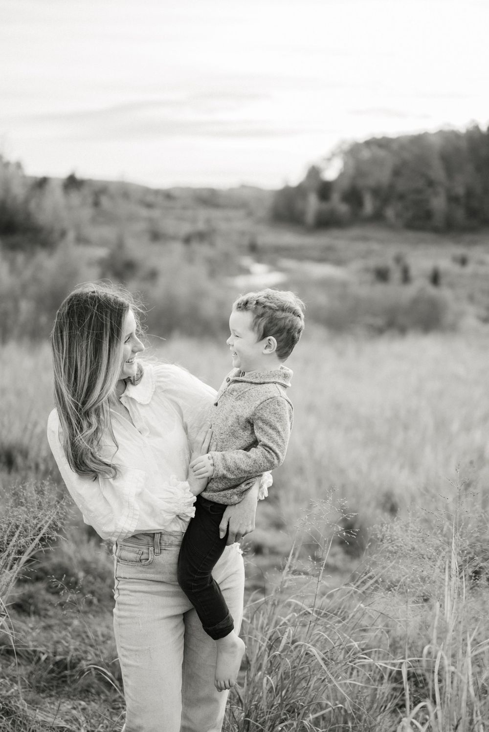 Black and white portrait of a tender moment in a scenic autumn field.