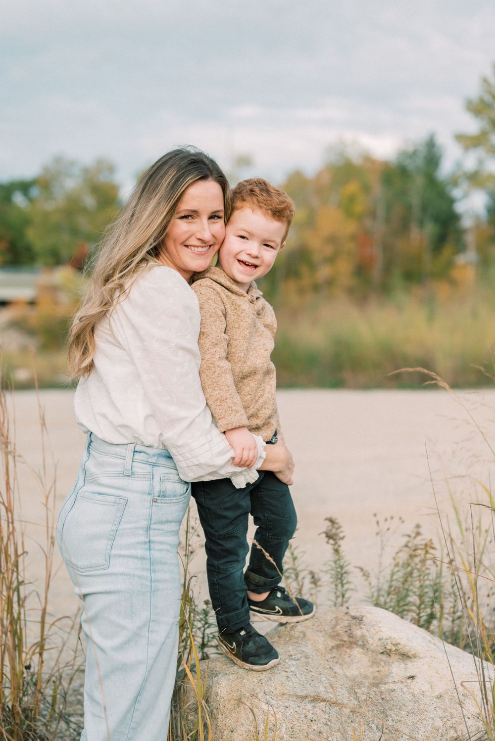 A sweet embrace captured against a backdrop of autumn colors and tall grass.