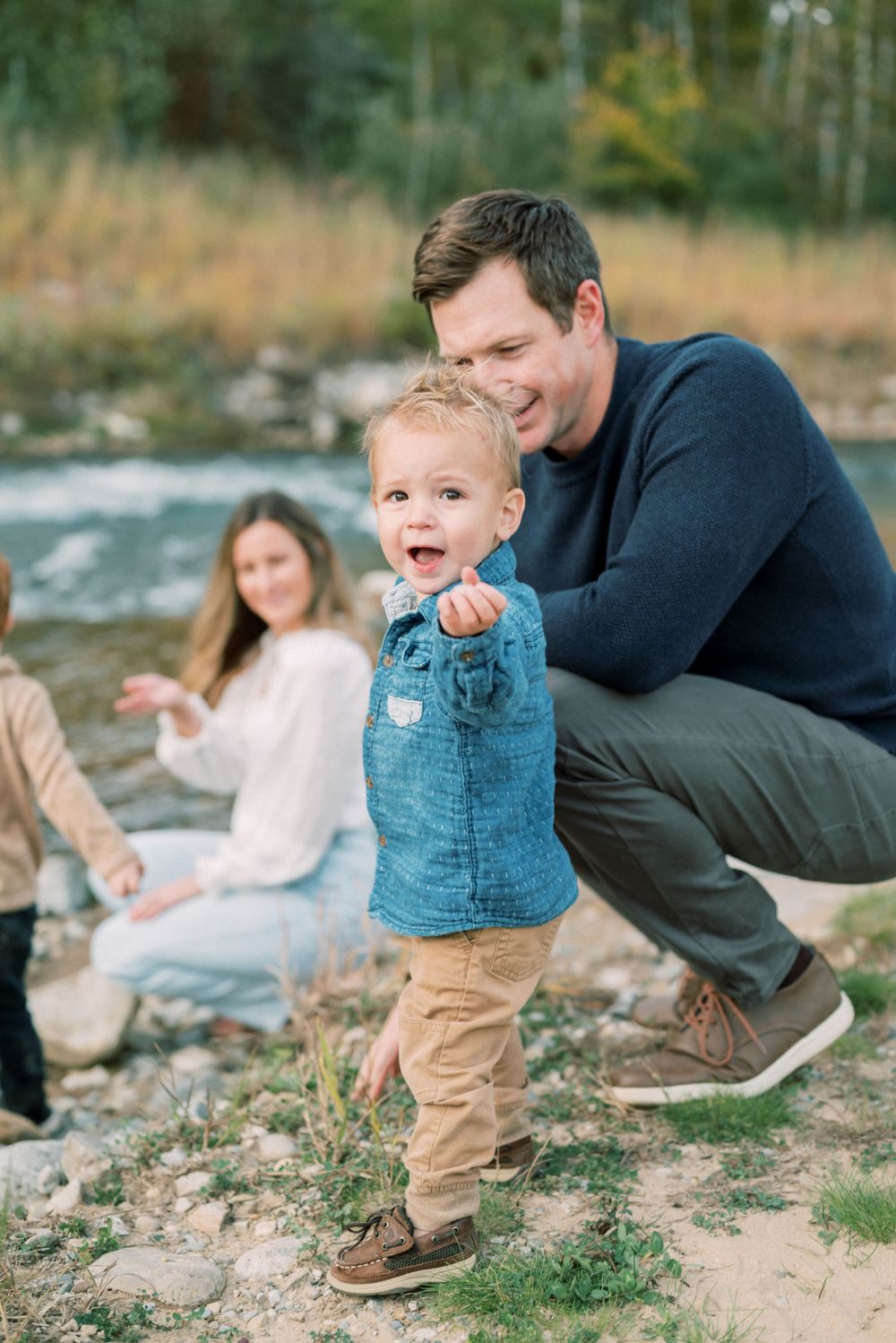 A joyful moment shared while sitting by a flowing stream surrounded by nature.