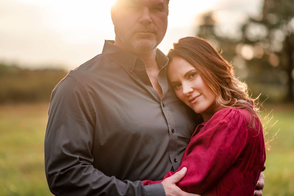 photo of a man and woman hugging at sunset