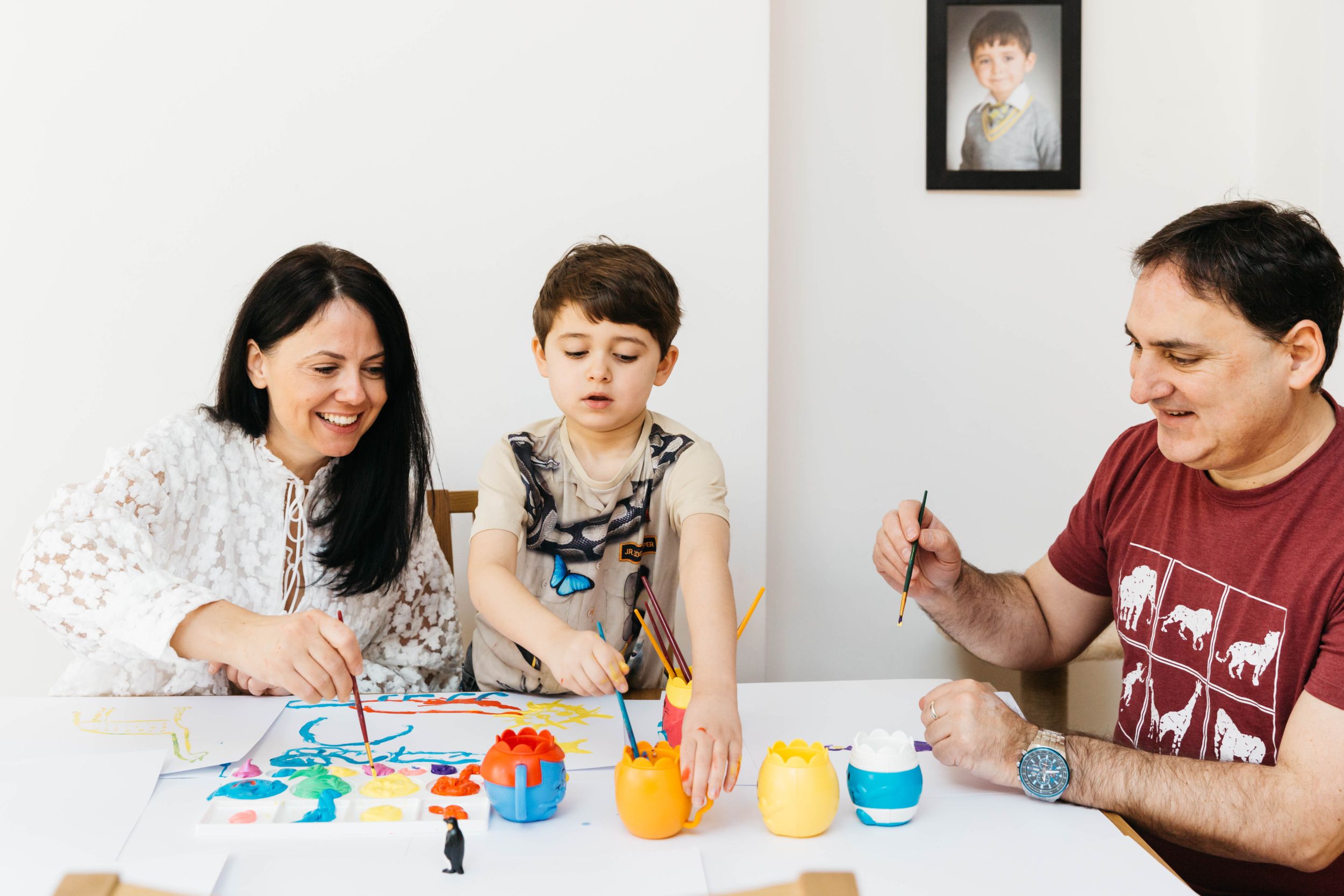 family of three at home with dog painting
