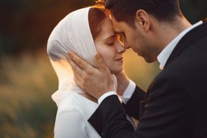 Intimate moment between couple sharing tender embrace outdoors at sunset.