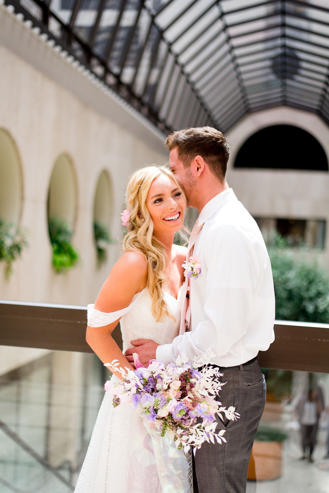 bride and groom laughing in atrium of The Center Cincinnati for spring wedding