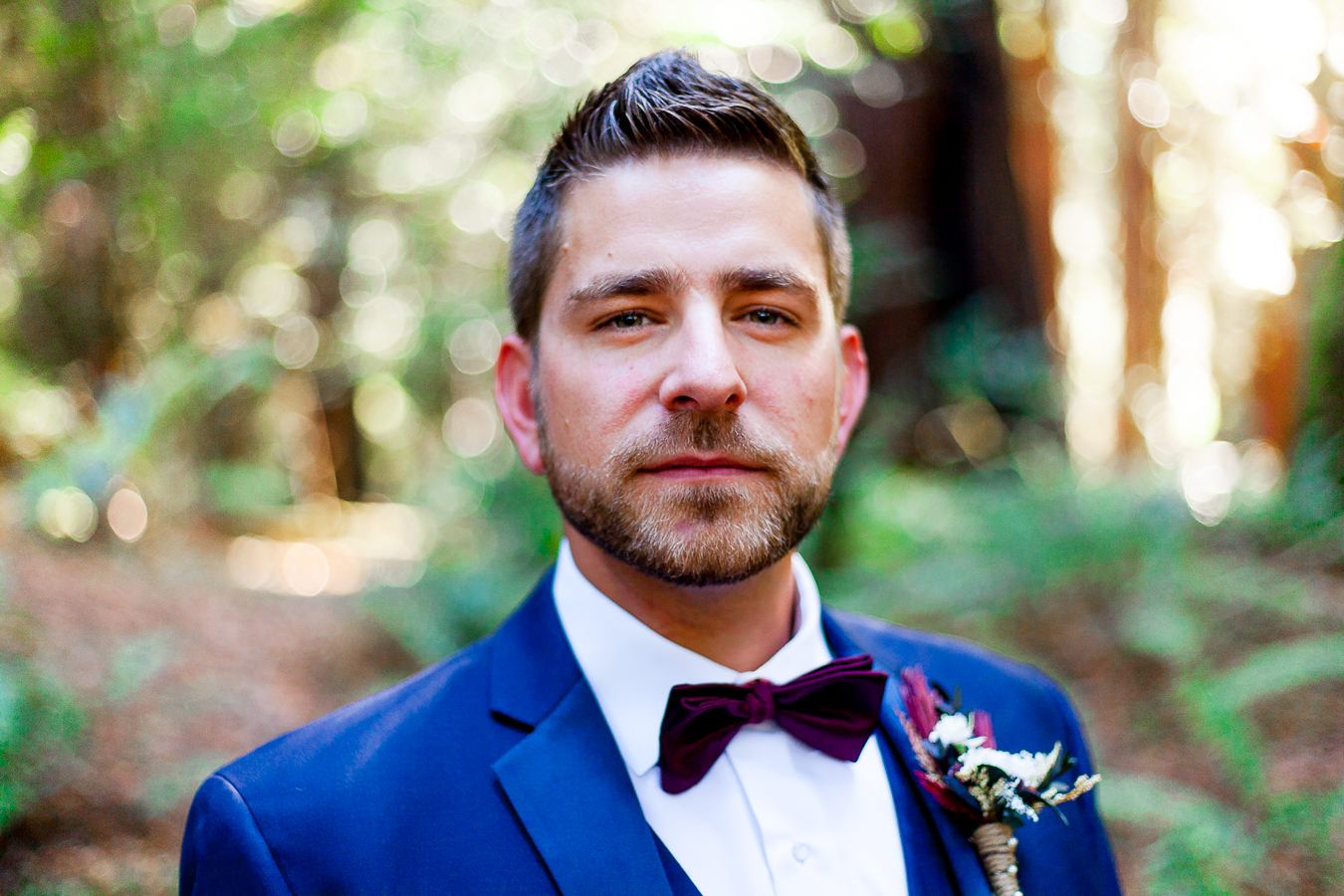 groom in navy suit and maroon bowtie in the Redwoods