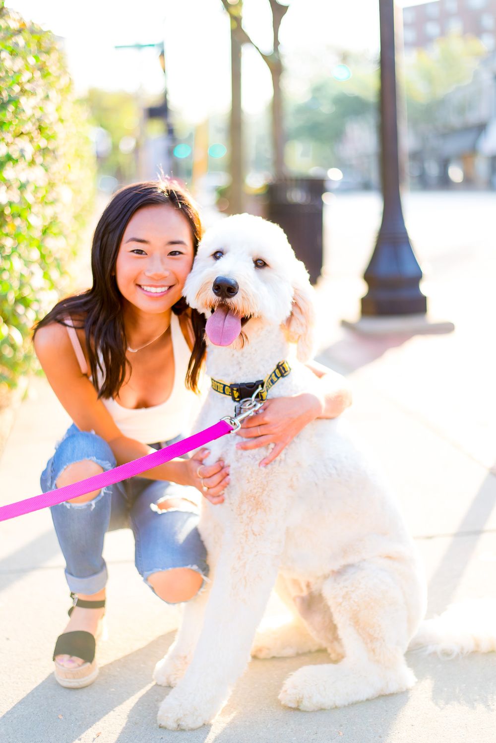high school girl hugging her dog on a sidewalk in downtown Chicago