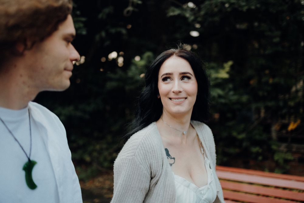Two people share a candid moment while sitting outdoors.