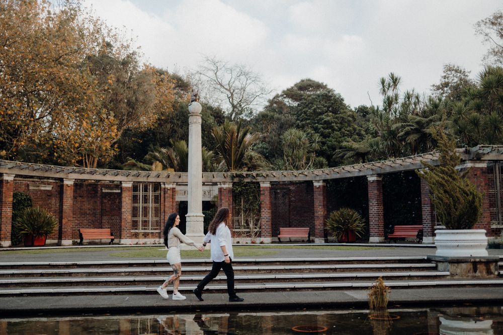 A couple walks along curved stone steps in a garden amphitheater setting.
