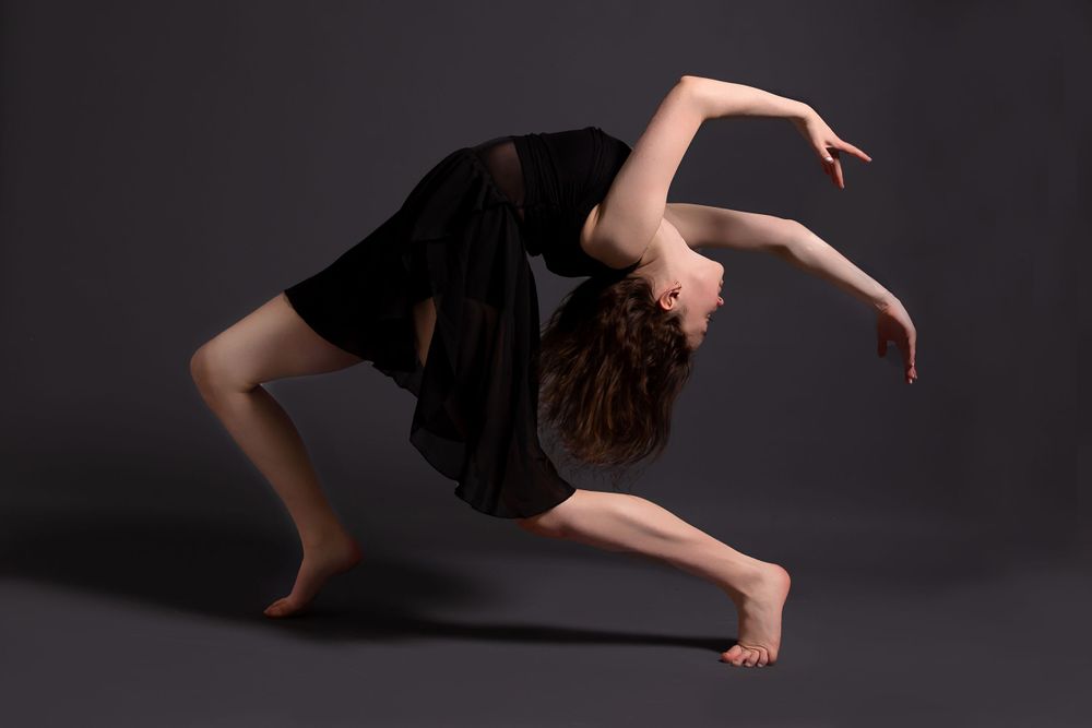 female dancer in black dress bending backwards