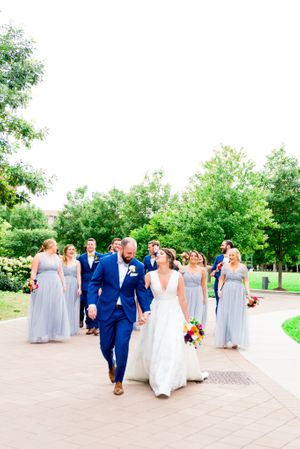 bride and groom in navy suit walking through Loyola University Campus at summer outdoor wedding in Chicago