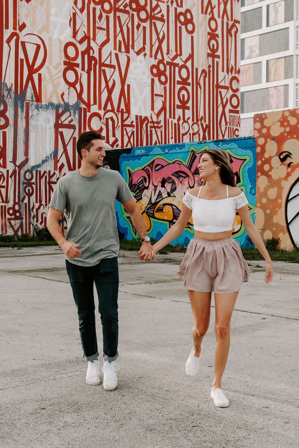 couple running through an empty parking lot during their Miami engagement