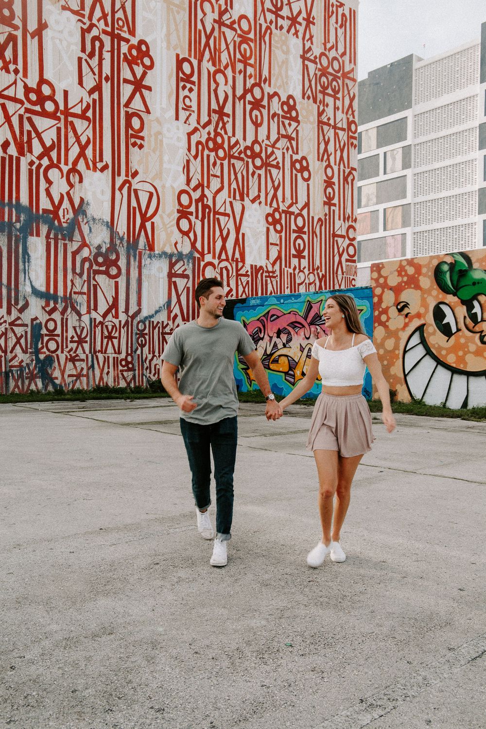 couple running through a parking lot during Fort Lauderdale engagement