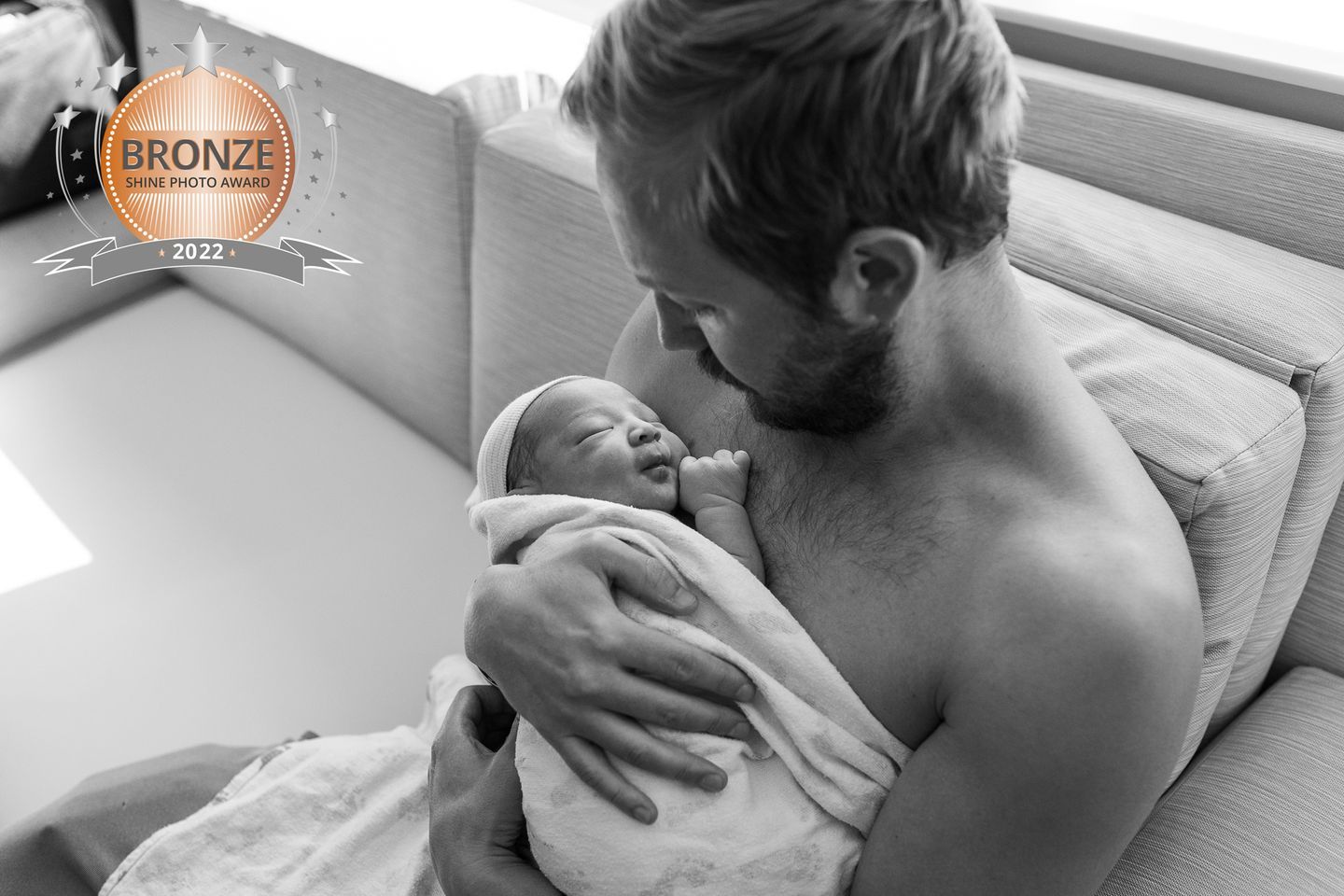 Father holds his son for the first time moments after his birth