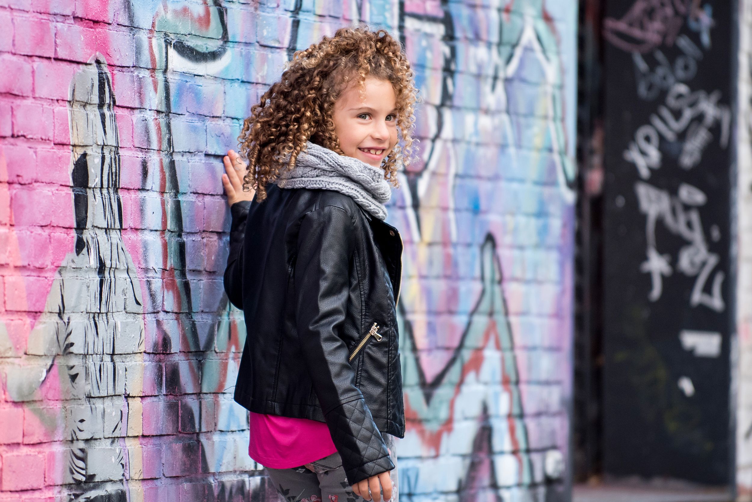 female child model wearing stylish clothes with graffiti background