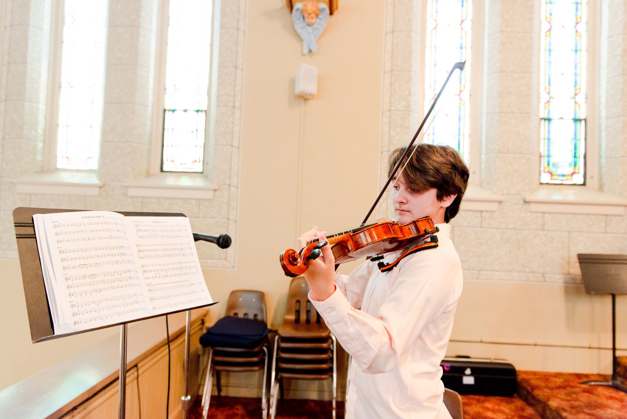 young man playing violin inside church for downtown STL wedding