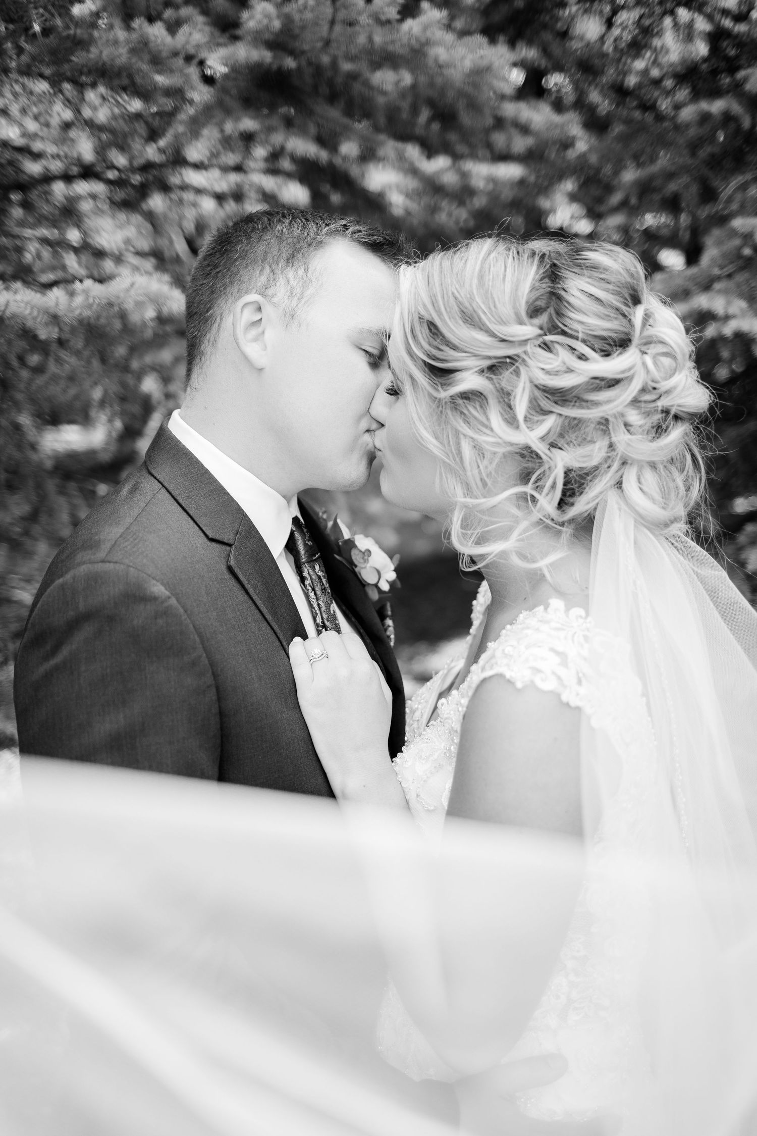 Bride and groom kissing with a swooshing veil