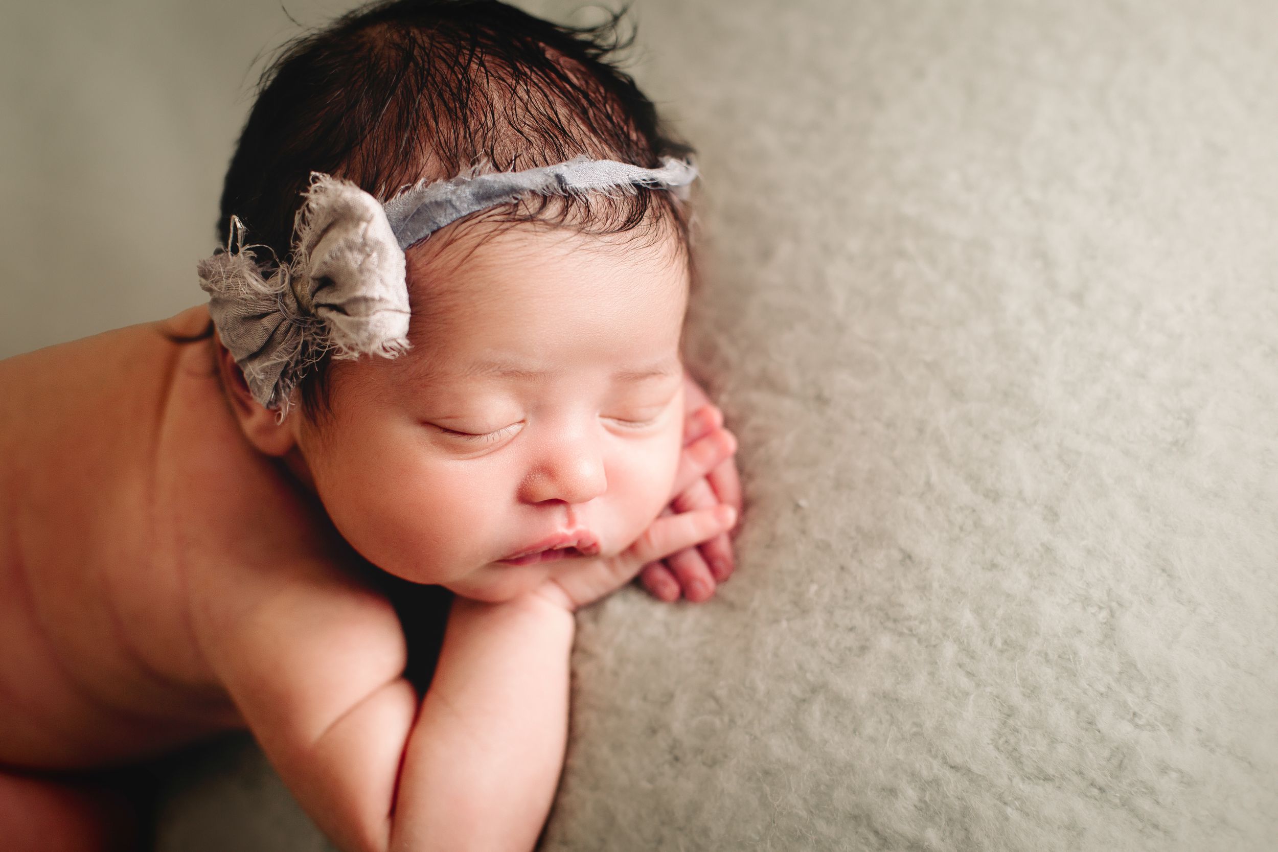close up of newborn's face on soft mint blanket