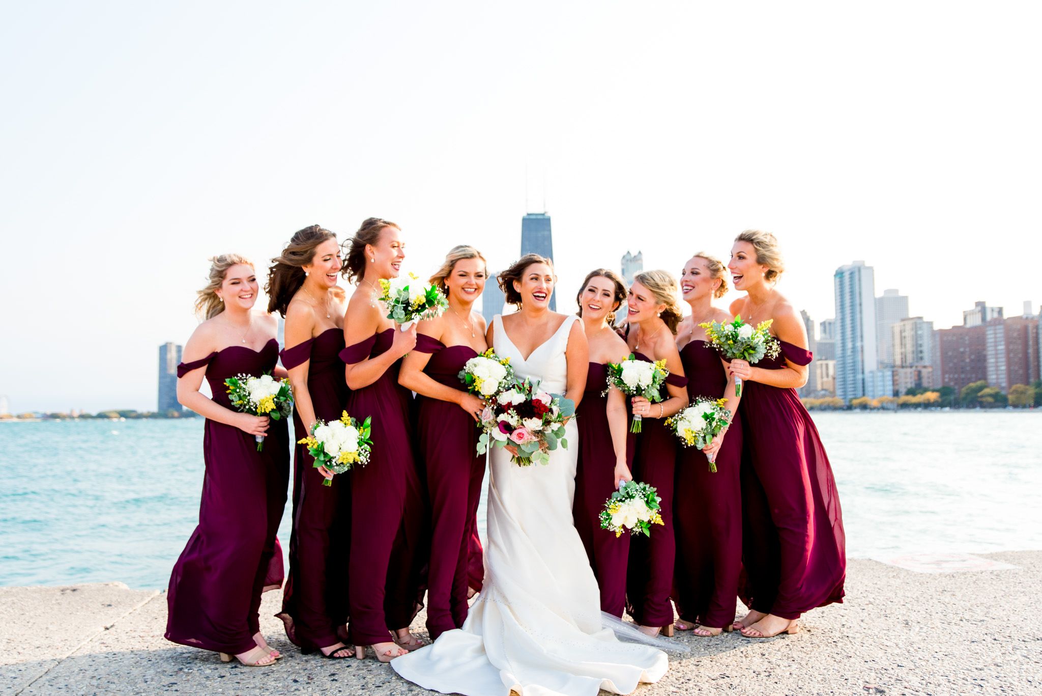 maroon bridesmaids take pictures with bride at north avenue beach pier