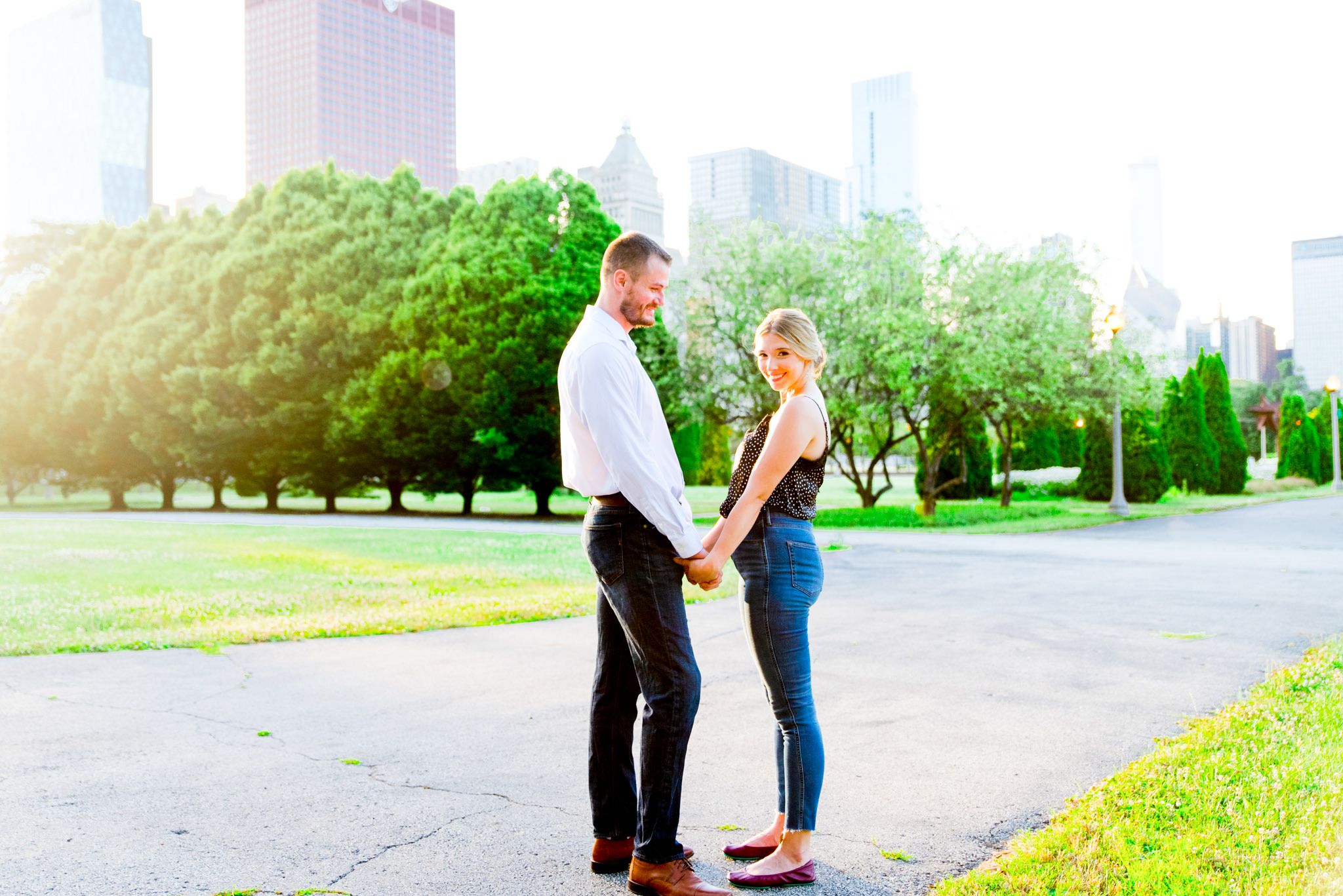 young man and woman holding hands smiling at each other in Chicago Grant Park at sunset