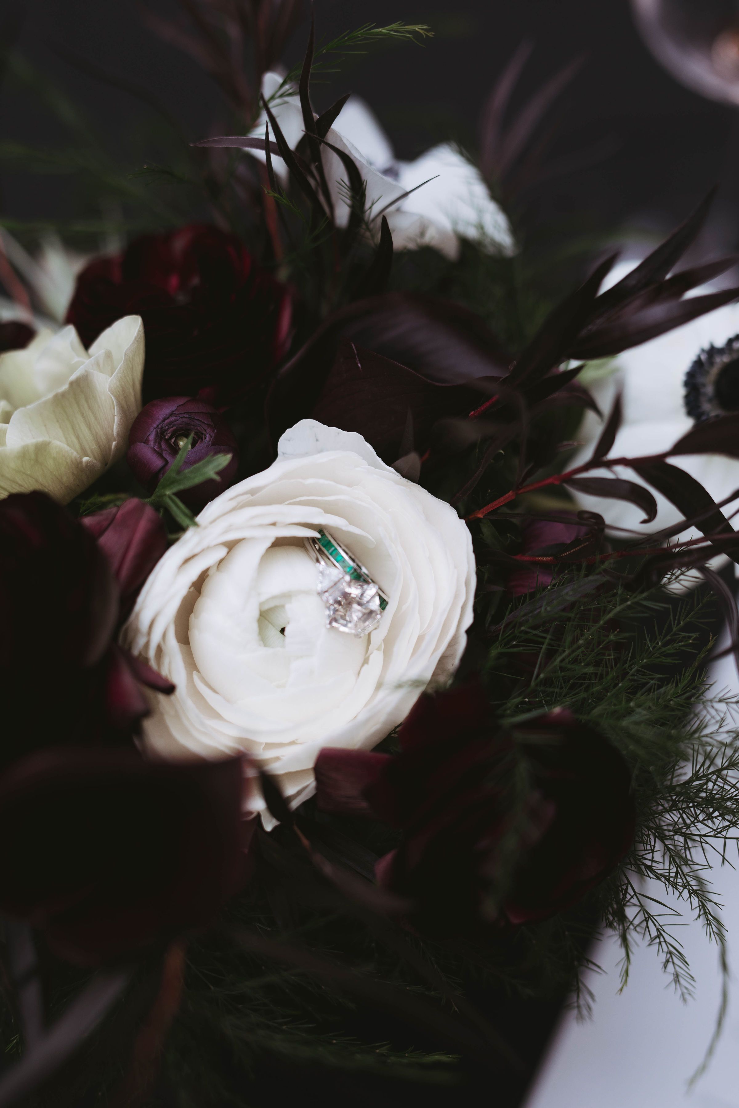Women's engagement and wedding rings displayed in a white flower