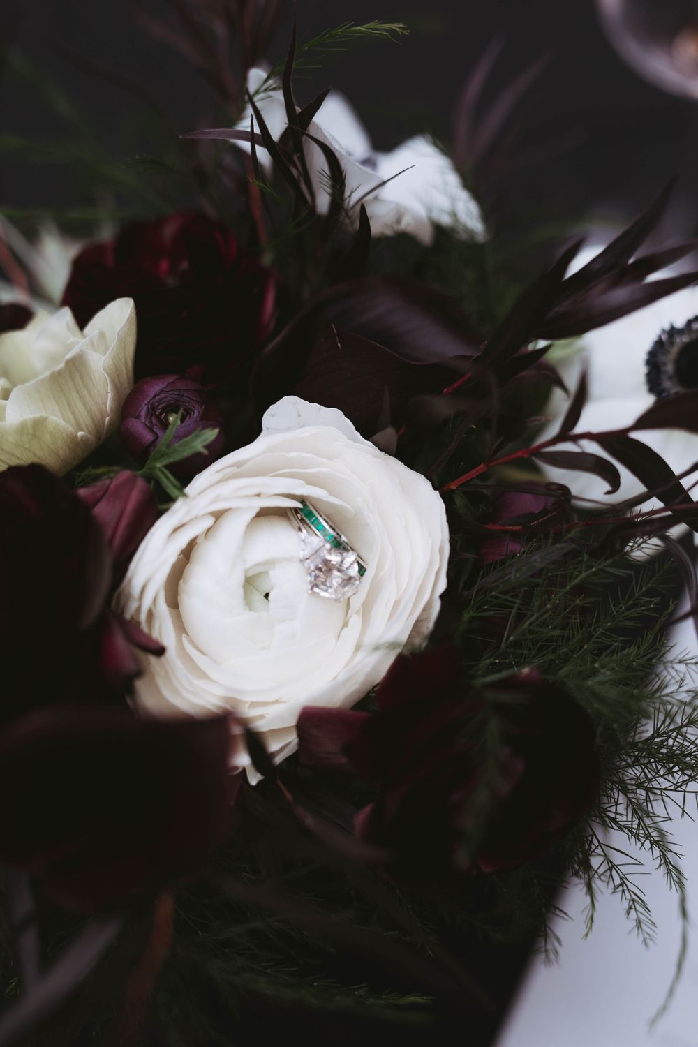 Women's engagement and wedding rings displayed in a white flower